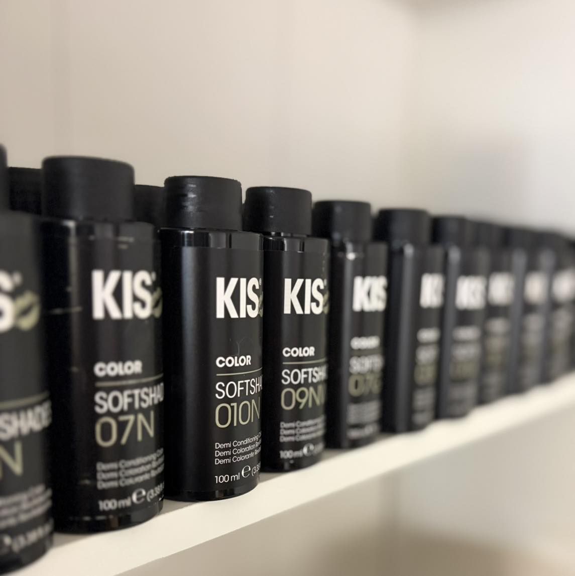 Een plank met KIS-kleurflessen in de salon