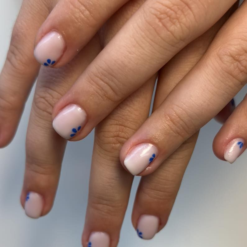 Nude gelnagels met kleine blauwe bloemetjes